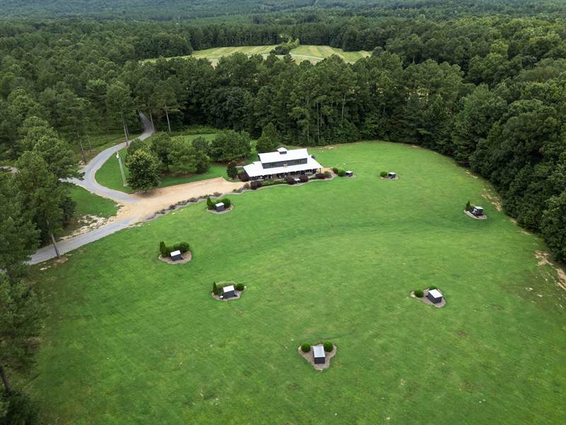 Overhead view of the shooting stations laid out in an arc across the mown field below the pavilion