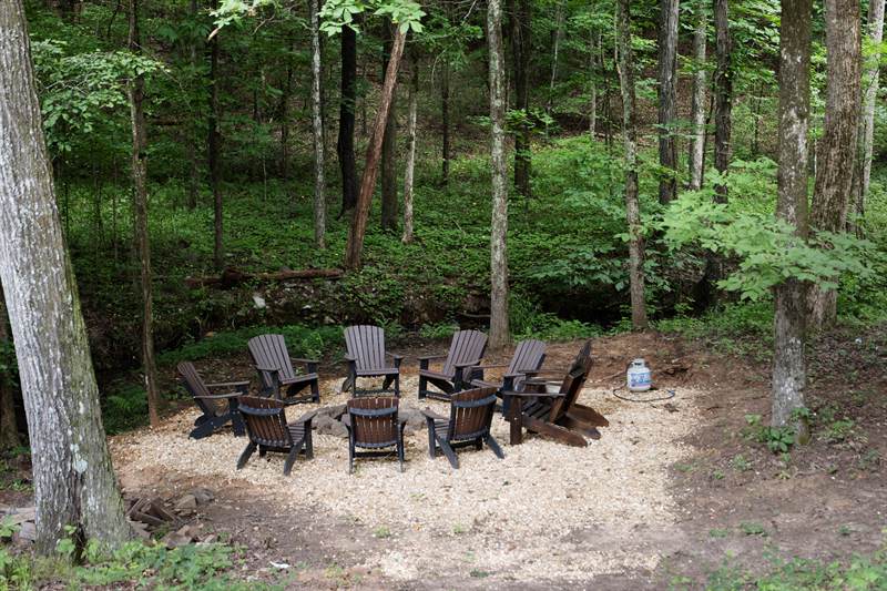 A gravel fire pit on the hillside below the lodge