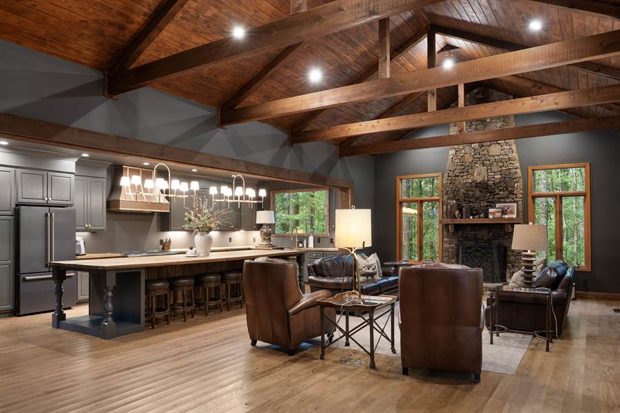 The lodge great room with timber trusses and a stone fireplace