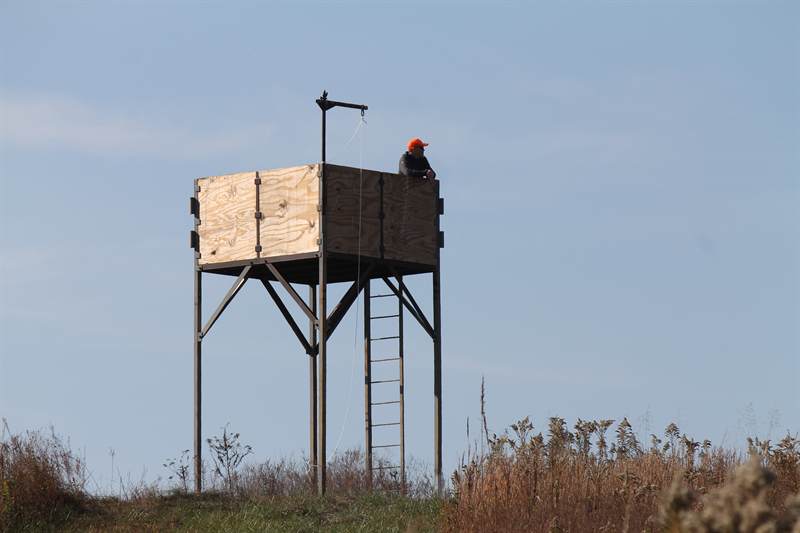 The release tower standing on a rise above broomsedge, with the ridge line beyond
